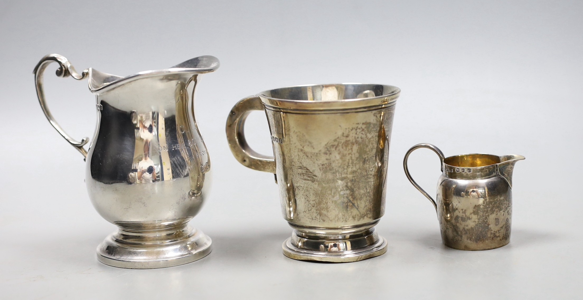 A 1960's silver cream jug, a small cream jug and a George V silver christening mug, 9.5 oz.